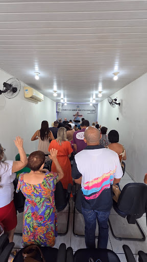 Comunhão de irmãos louvando em pé no corredor do templo da Casa do Conselheiro