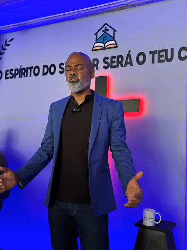 Bispo Willians em oração com as mãos estendidas clamando pela congregação